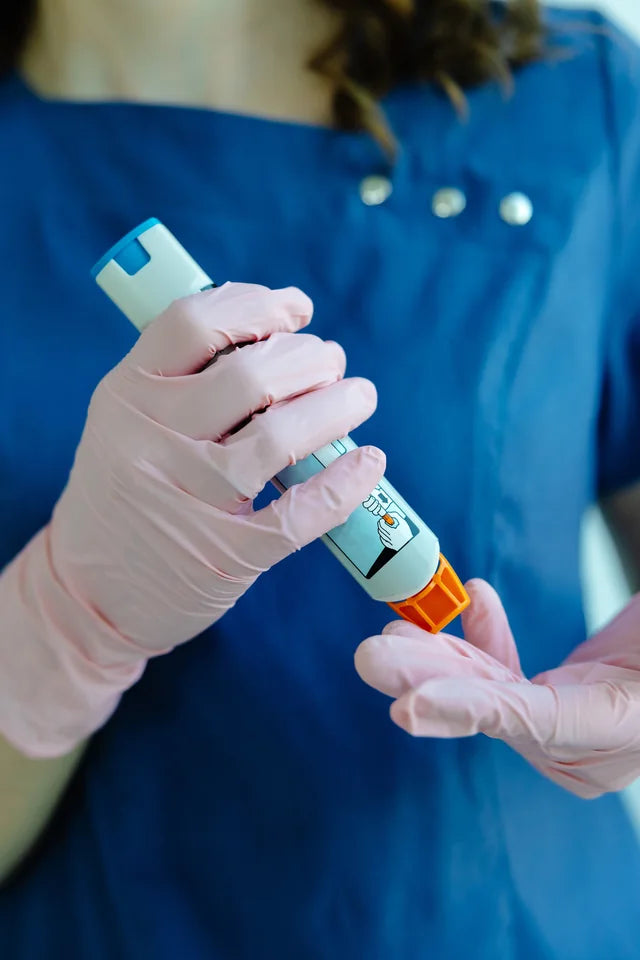A health professional demonstrating an adrenaline auto-injector