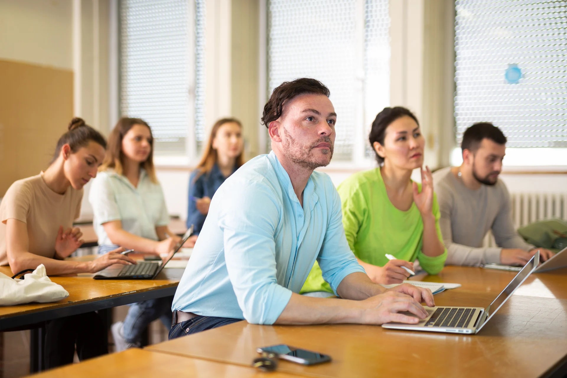 An adult learner using a laptop during class