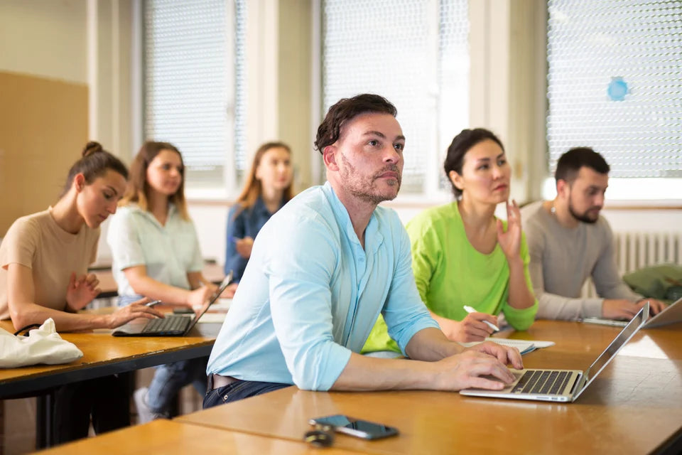 An adult learner using a laptop during class