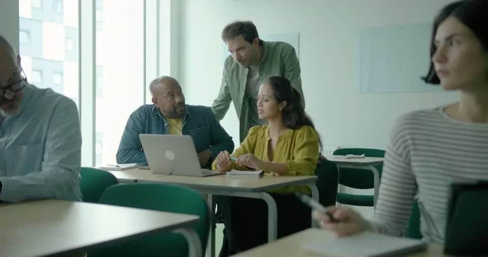 A trainer answering questions and guiding adult learners