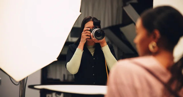 A photographer working with a camera in a studio