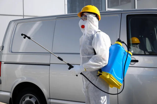 A pest management worker preparing spray equipment